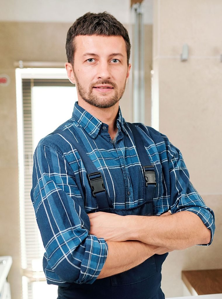 young-successful-plumber-in-workwear-standing-in-b-3P7U6YB.jpg